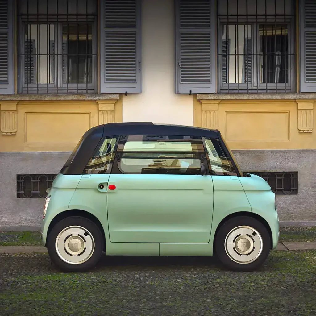 Elektrische Fiat Topolino geparkeerd voor een gevel